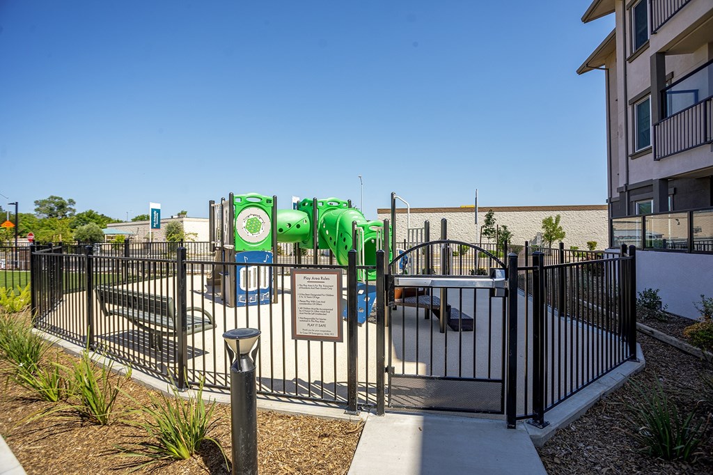 Kids playground with a slide surrounded by a fence