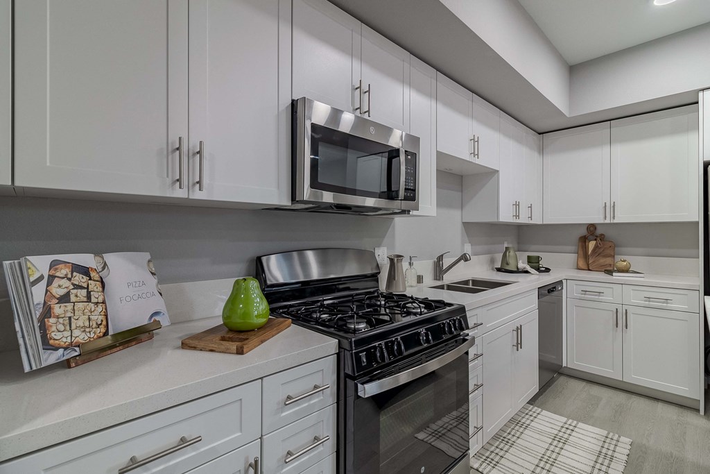 A modern kitchen with a stove, microwave, and oven.
