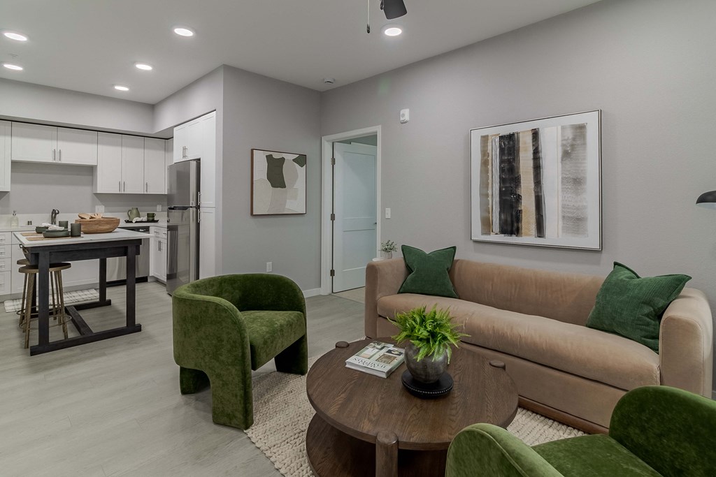 A modern living room with a green armchair and a brown sofa.