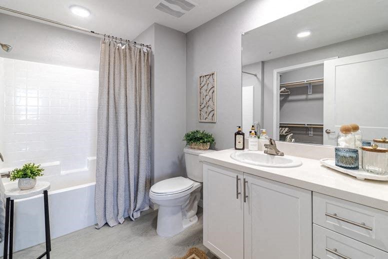 A white bathroom with a toilet, sink, and shower.