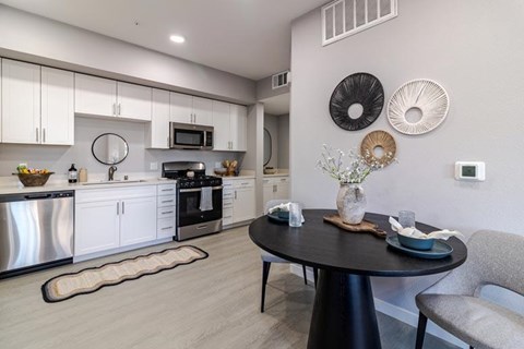 A modern kitchen with a dining table and chairs.