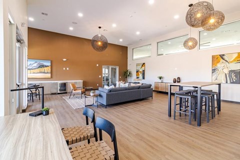 A modern living room with a grey sofa and a wooden dining table.