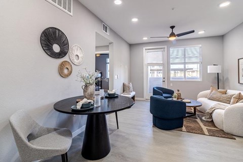 A modern living room with a black table and grey chairs.