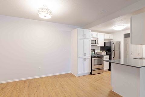 A kitchen with white cabinets and a black countertop.