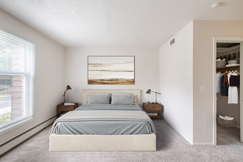 A bedroom with a large bed and a painting on the wall.
