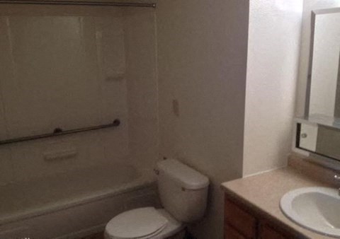 a bathroom with a toilet and a sink and a bath tub a bathroom with a toilet and a sink and a bath tub at Woodridge Apartments, Kenai, AK, 99611