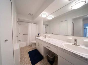 a bathroom with two sinks a toilet and a bathtub