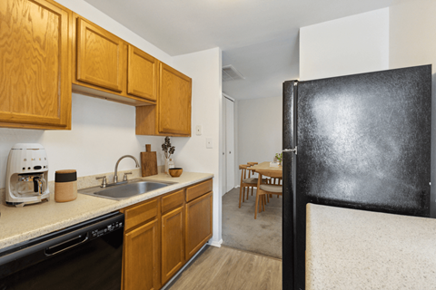 a kitchen with a sink and refrigerator and a dining room with a table