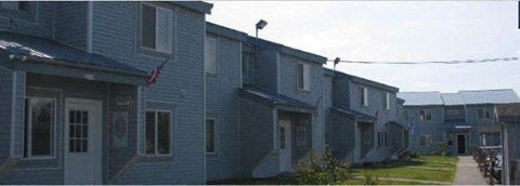 a row of blue houses on a street a row of blue houses on a street at Woodridge Apartments, Kenai, AK