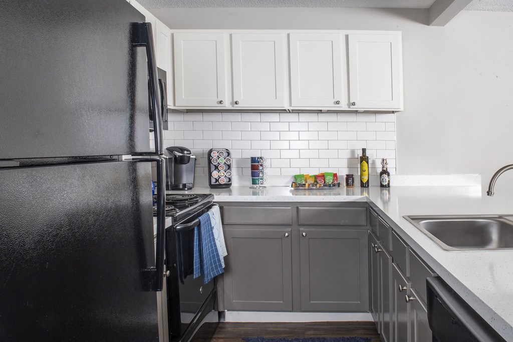 a kitchen with white cabinets and black appliances at Fifteen 98 Naperville, Naperville, 60563