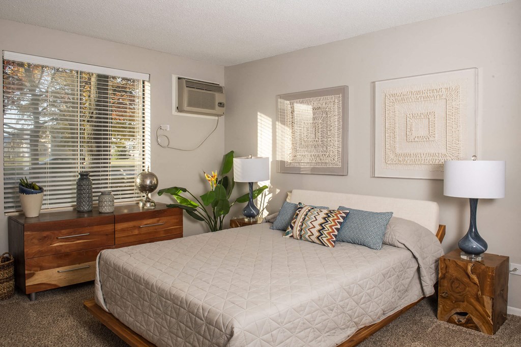 a bedroom with a bed and a dresser in front of a window  at Fifteen 98 Naperville, Naperville, IL