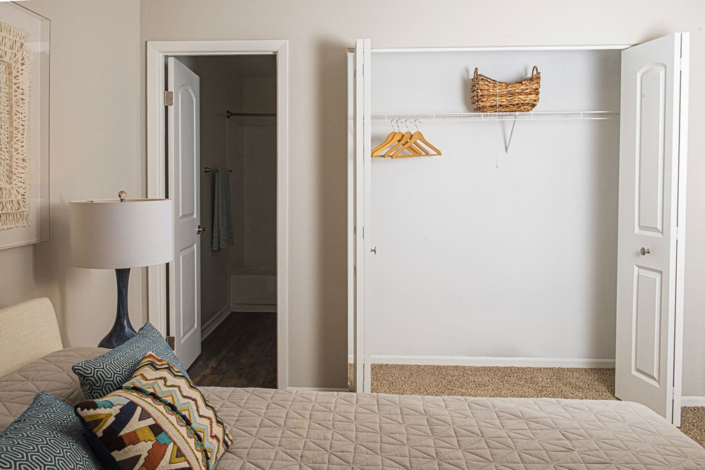 a bedroom with white walls and a white bed with blue pillows at Fifteen 98 Naperville, Naperville