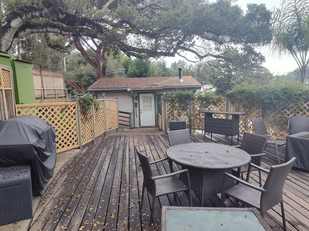 A wooden deck with a table and chairs at Salinas Sunset Apartments, Salinas, California