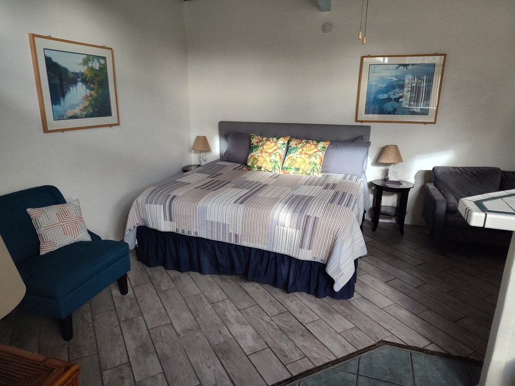 A bedroom with a bed, chair, and two lamps at Salinas Sunset Apartments, Salinas, 93907