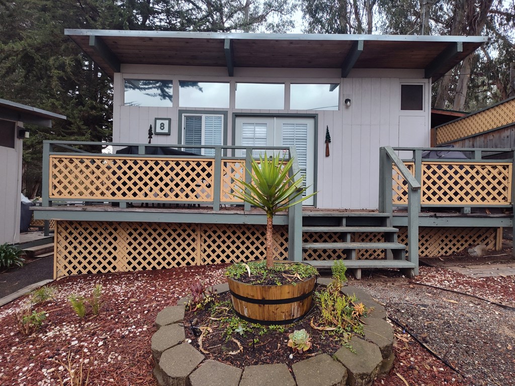 Cabin with a wooden deck and a potted plant in front at Salinas Sunset Apartments, California, 93907