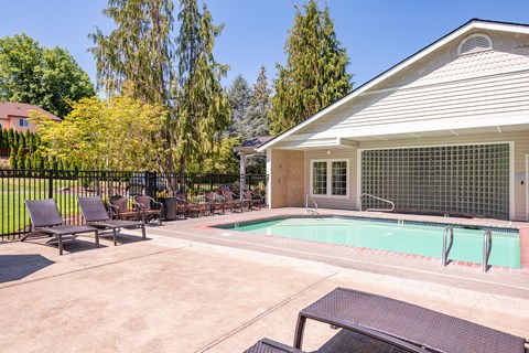a swimming pool in front of a house with patio furniture at Murrayhill Park, Beaverton Oregon