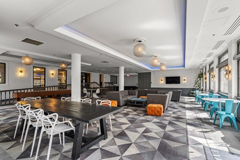 A large room with a black table surrounded by white chairs at The Exeter Apartments, Seattle, WA, 98101