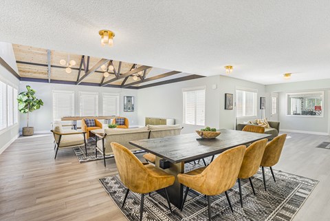 A large room with a table and a room with a shuffleboard table in the background