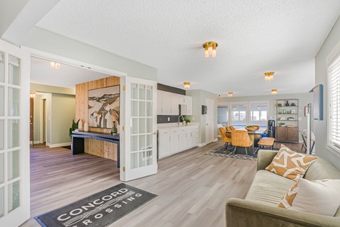 A living room with a couch and a rug that says Concord Roses.