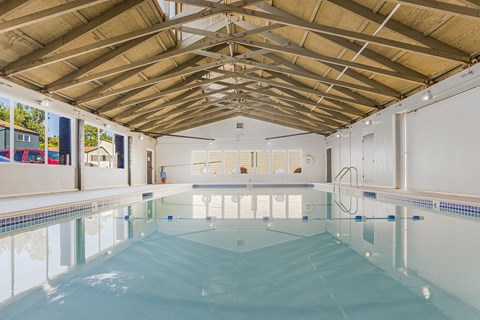 A large indoor swimming pool with a wooden ceiling.