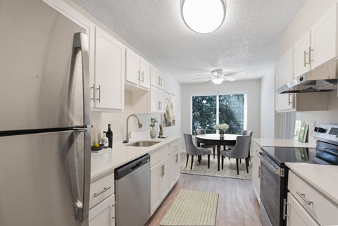 A kitchen with a table and chairs in the middle.