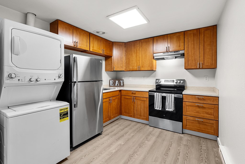 A kitchen with a white fridge, stove, and oven.