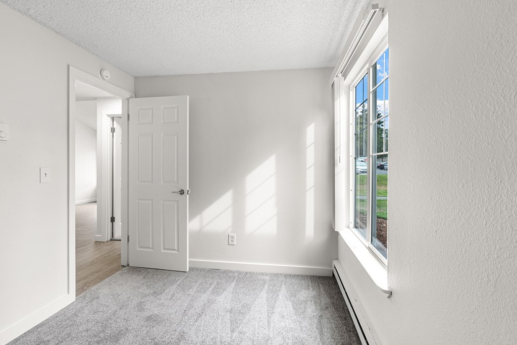 A white room with a door and a window.