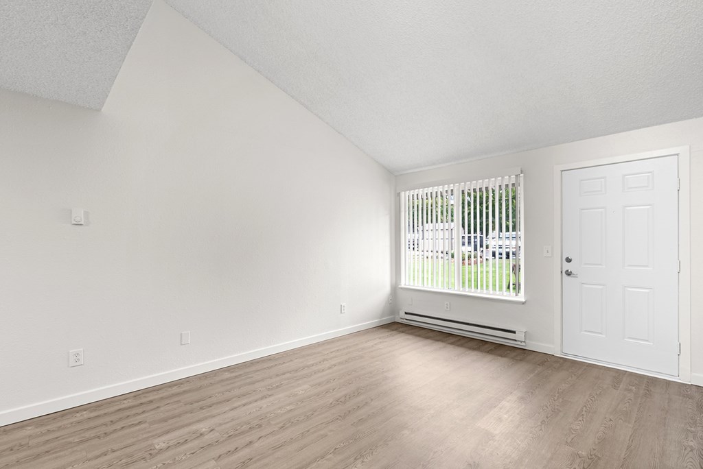 A room with a white door and a window with blinds.