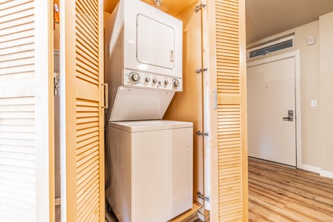 Stacked washer dryer unit in closet with louvered doors at Brooklyn Yard Apartments, Portland, 97202
