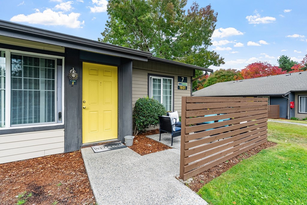 Apartment exterior with a yellow door and patio