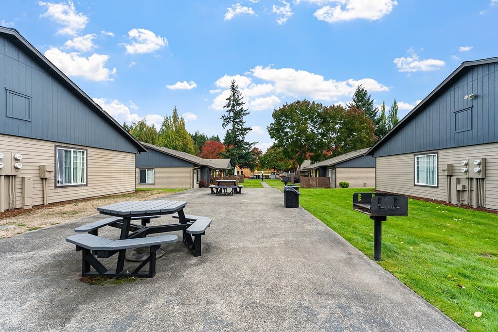 A picnic table is in the middle of a courtyard between two apartment buildings.