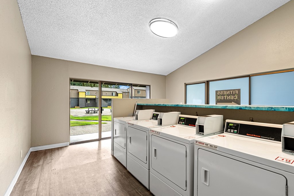 A laundry room with washers and dryers.