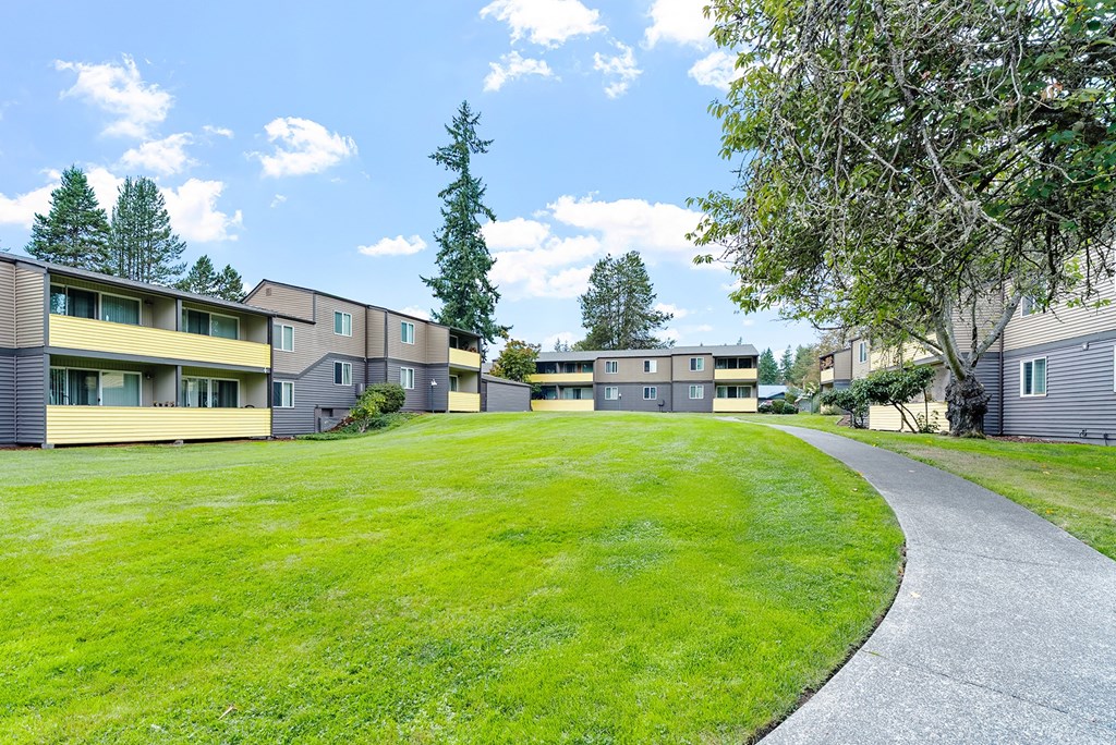 A grassy area in front of apartment buildings.