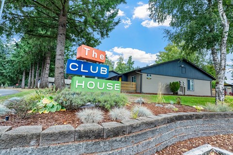 A sign that says The Club House is in front of a building.