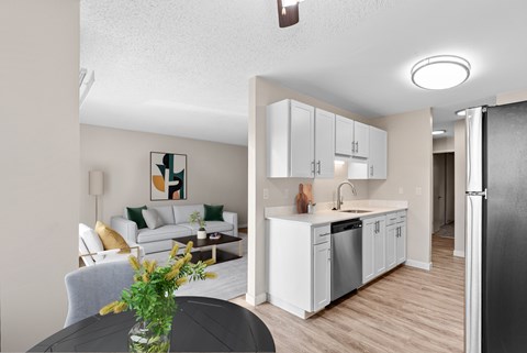 A modern kitchen with white cabinets and a black refrigerator.