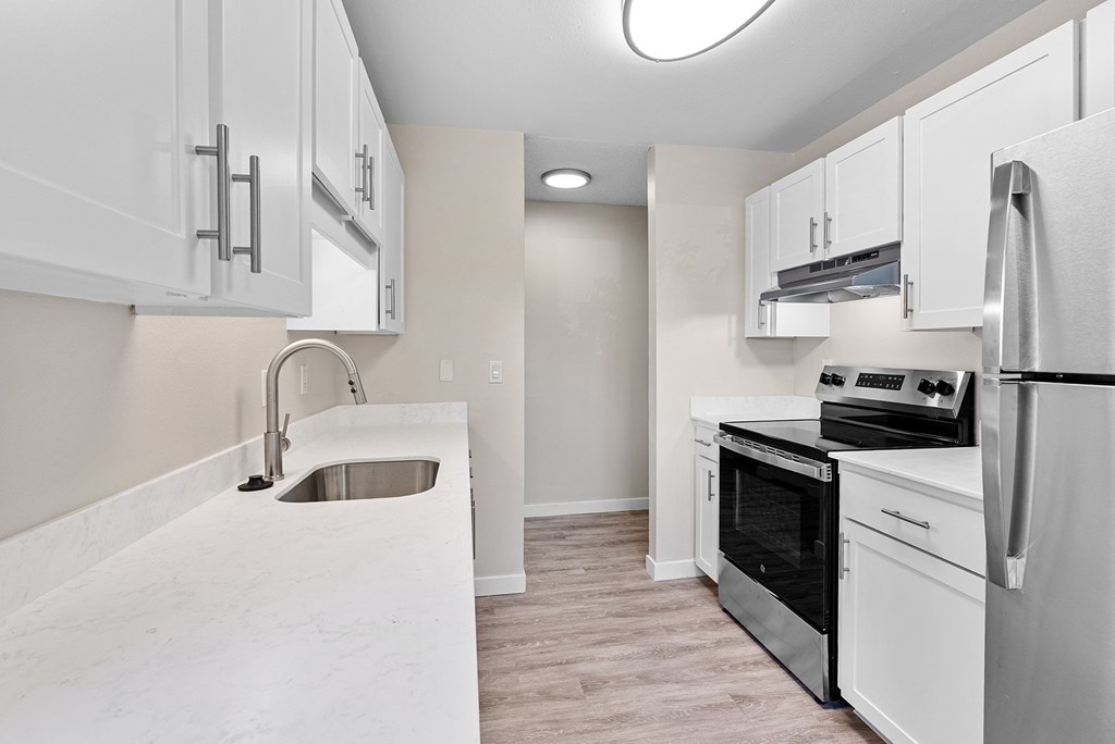 A kitchen with white appliances and cabinets.