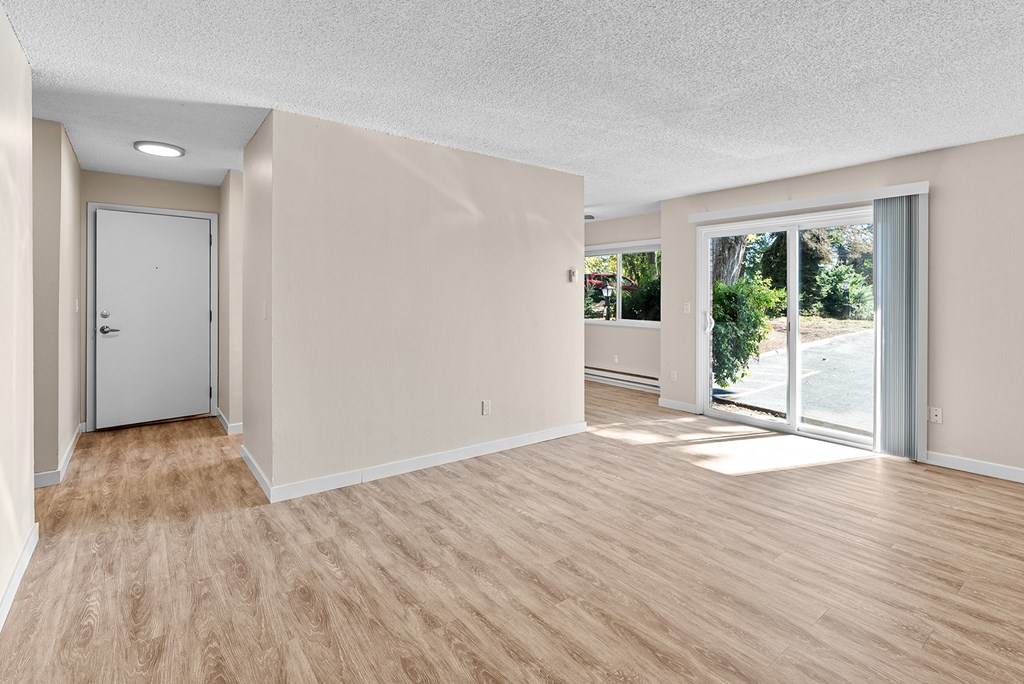 A room with a sliding glass door leading to a backyard.