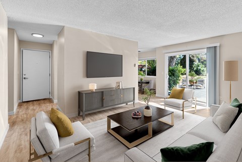 A modern living room with a grey sofa, a coffee table, and a flat screen TV mounted on the wall.