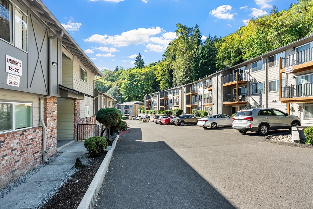 Apartment exteriors with a parking lot and trees