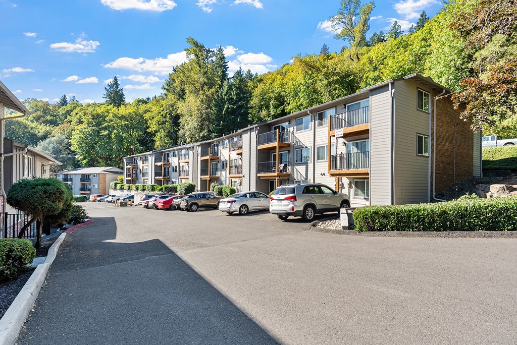 Apartment exterior with a parking lot and surrounding trees