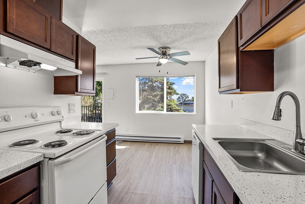 A kitchen with white appliances and wooden cabinets.