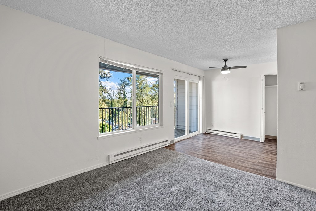 Carpeted living room with a view of the dinning area and balcony
