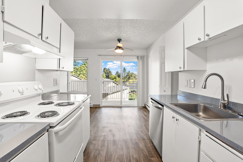 A kitchen with white appliances and cabinets.