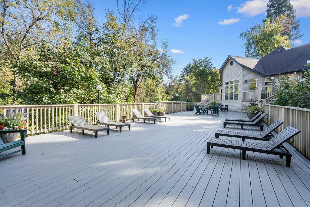 A deck with benches and a house in the background.