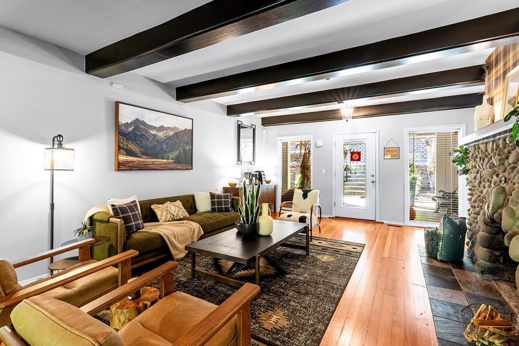 Sitting room with chairs, fireplace and wooden beams