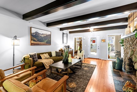 A living room with a couch, a chair, a coffee table, and a painting on the wall.