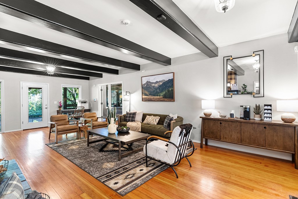 A sitting room with a black and white striped ceiling and a large painting on the wall.