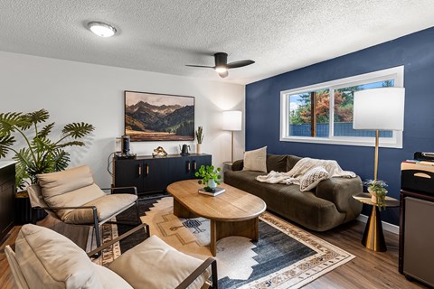 A living room with a brown sofa, a wooden coffee table, and a painting on the wall.