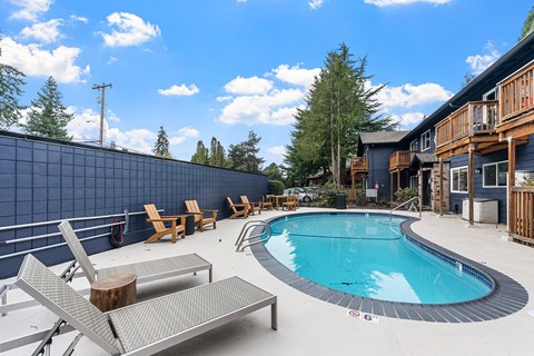 A pool with a bench and a wall in the background.