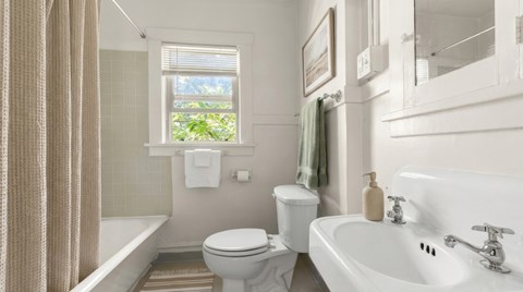 A white bathroom with a toilet, sink, and bathtub.